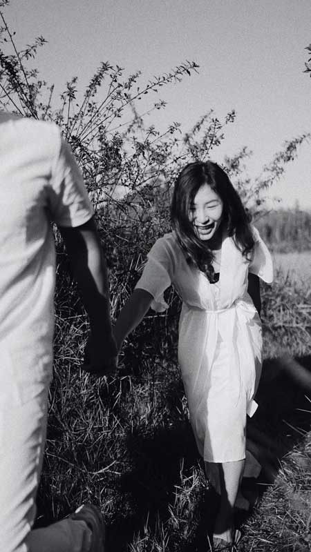 This woman is walking through a field with a huge smile on her face, holding someone's hand who is leading her forward. Together, we can change the world.