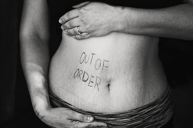 A woman stands with her midriff exposed, showing her stretchmarks with the words, Out of Order written across her stomach. The narrative is that a woman is useless when she can no longer reproduce.