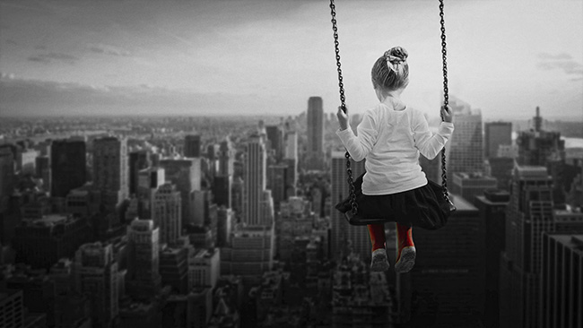 Girl on a swing overlooking the city