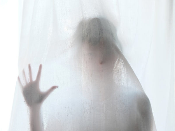 woman behind curtain